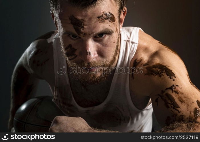 athletic dirty male rugby player holding ball