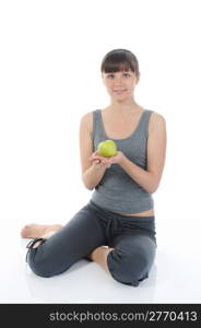 Athletic girl holding a green apple in hand. Isolated on white background