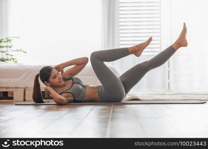 Athletic Healthy Asian indian woman in sportswear workout excercise at home in bedroom,Young woman with slim body cardio aerobic exercises healthy lifestyle concept