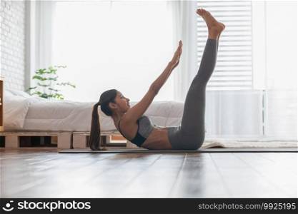 Athletic Healthy Asian indian woman in sportswear workout excercise at home in bedroom,Young woman with slim body cardio aerobic exercises healthy lifestyle concept