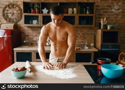 Athletic husband in underwear cooking on the kitchen. Naked man preparing breakfast at home, food preparation without clothes. Athletic husband in underwear cooking on kitchen