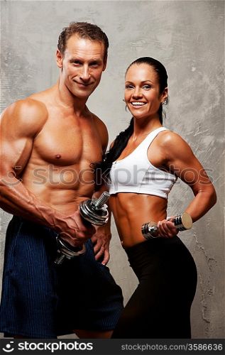 Athletic man and woman with a dumbbells.