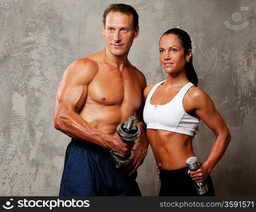 Athletic man and woman with a dumbbells.