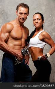 Athletic man and woman with a dumbbells.