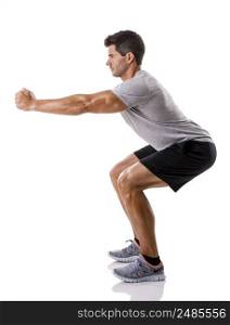 Athletic man running doing squats, isolated over a white background