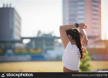 Athletic woman asian warming up and Young female athlete sitting on an exercising and stretching in a city before Runner outdoors, healthy lifestyle concept