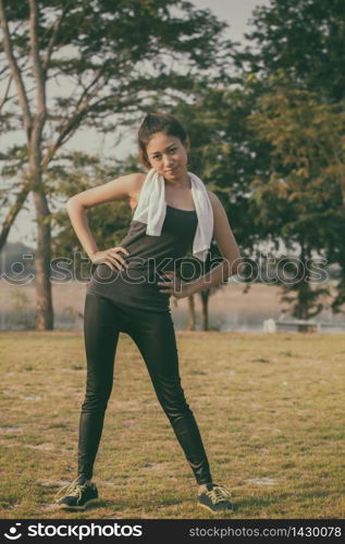 Athletic woman asian warming up and Young female athlete sitting on an exercising and stretching in a park before Runner outdoors, healthy lifestyle concept,soft focus