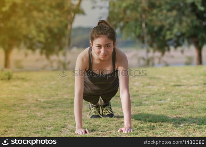 Athletic woman asian warming up and Young female athlete sitting on an exercising and stretching in a park before Runner outdoors, healthy lifestyle concept