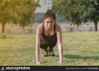 Athletic woman asian warming up and Young female athlete sitting on an exercising and stretching in a park before Runner outdoors, healthy lifestyle concept