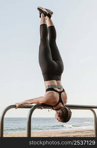 athletic woman doing exercises outside by beach