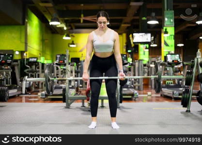 Athletic woman exercising deadlift in a gym. High quality photo. Athletic woman exercising deadlift in a gym.