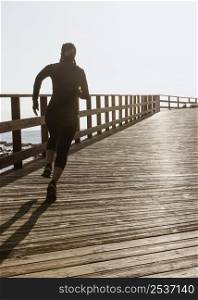 athletic woman jogging by beach with copy space