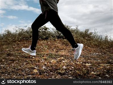 Athletic woman running on forest trail. Female runners running in nature in the morning. Workout Healthy lifestyle concept. close-up legs with running shoes.