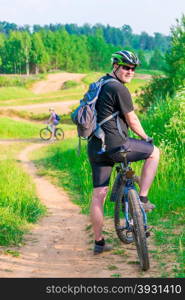 athletic young couple on bicycles on a clay road