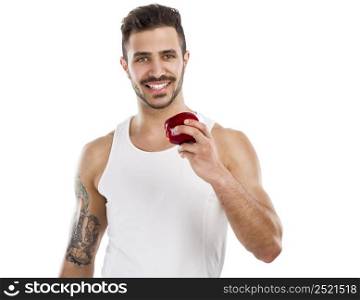 Athletic young man holding a fresh apple, isolated over a white background