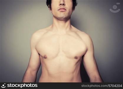 Athletic young man is posing shirtless