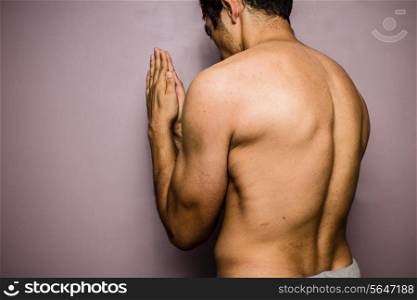 Athletic young man praying
