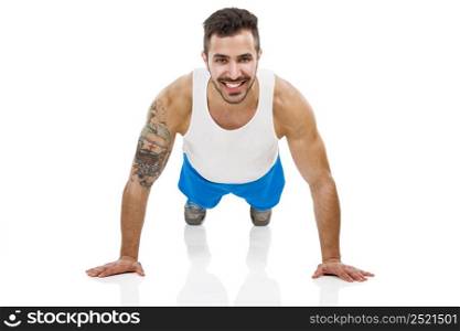 Athletic young man smiling and making pushups, isolated over a white background