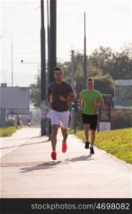 athletic young men enjoy running while the sun rises over the city