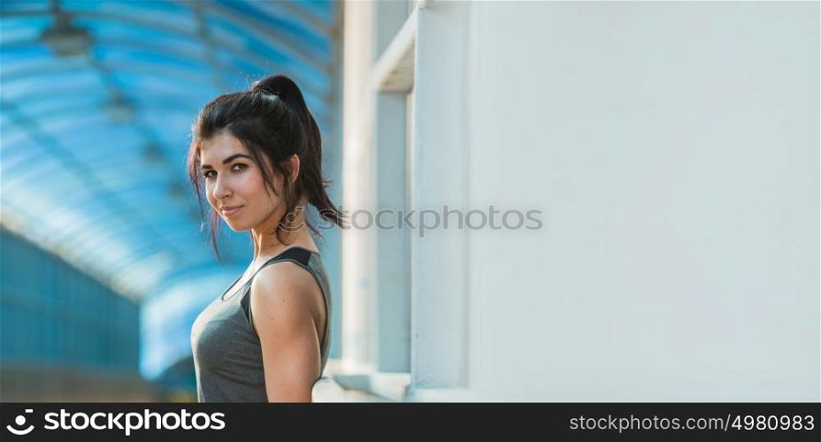Athletic young woman looking at camera while resting during workout. Lots of copyspace