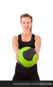 Athletic young woman training with green ball isolated on white