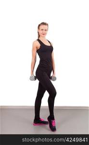 Athletic young woman with dumbbells in the gym