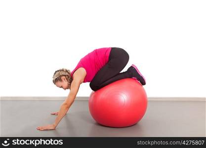 Athletic young woman with red ball on the floor