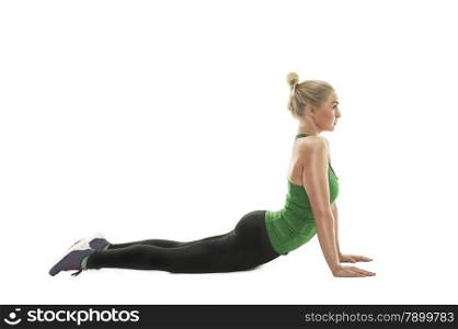 Athletic young woman working out in a gym doing push-ups, side view with arms extended and body raised isolated on white