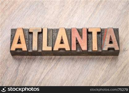 Atlanta word abstract in vintage letterpress wood type against grained wooden background