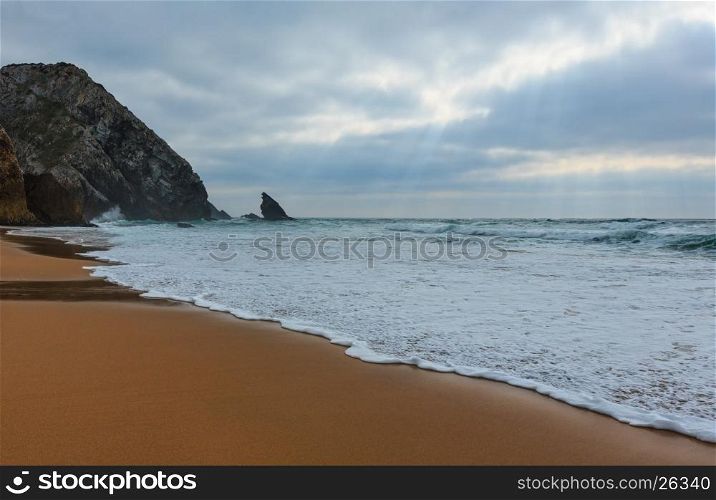 Atlantic ocean coast view (granite boulders, sea cliffs and beach) in cloudy stormy weather near Cape Roca (Cabo da Roca), Portugal.