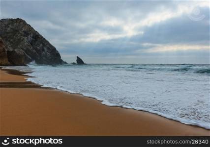 Atlantic ocean coast view (granite boulders, sea cliffs and beach) in cloudy stormy weather near Cape Roca (Cabo da Roca), Portugal.