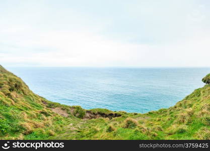 Atlantic ocean overcast sky and field of green grass, Ireland Europe