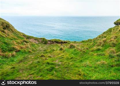 Atlantic ocean overcast sky and field of green grass, Ireland Europe