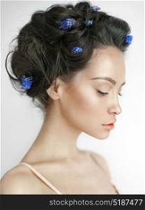 Atmospheric art-fashion portrait of beautiful young woman with blue muscari in her hair. Spring vibes. Summer freshness