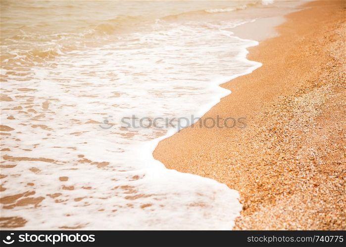 Atmospheric, melancholic mood, blurred background with copy space. View of shell beach and sea foaming waves. For design mockup, screensaver for device, content for social media. Horizontal