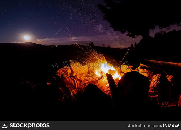 Atmospheric night around the campfire in the Black Forest with a super full moon and the Milky Way.