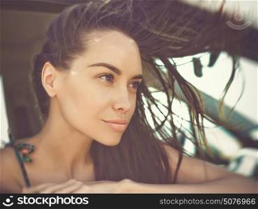Atmospheric outdoors fashion portrait of beautiful brunette woman in car on the beach. Summer trip. Summer vibes