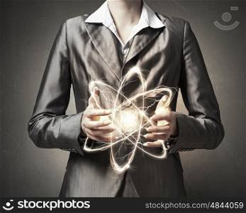 Atom molecule in hands. Close view of woman scientist presenting atom research concept