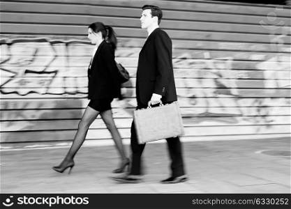 Atractive business people walking in the street. Couple working.