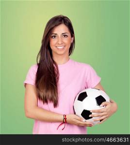 Atractive girl with a soccer ball isolated on green background