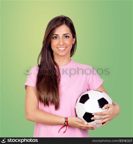 Atractive girl with a soccer ball isolated on green background