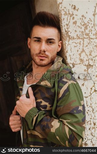 Atractive guy with jacket with military stylish in a vintage house