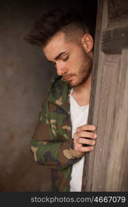 Atractive guy with jacket with military stylish in a vintage house