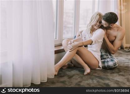 Atracttive loving couple sitting on the floor in the room