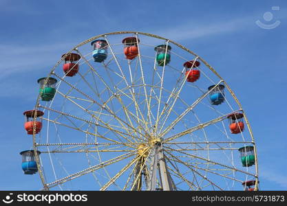 Atraktsion colorful ferris wheel against the blue sky