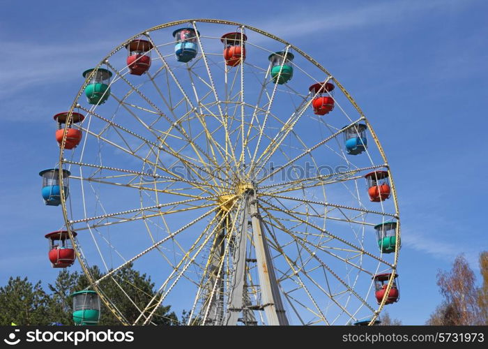 Atraktsion colorful ferris wheel against the blue sky