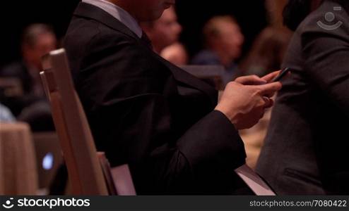 Attendee using phone at a conference