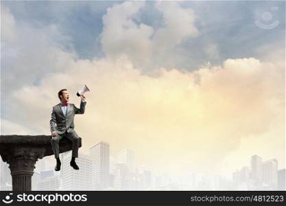 Attention everyone. Businessman sitting on top and screaming in megaphone