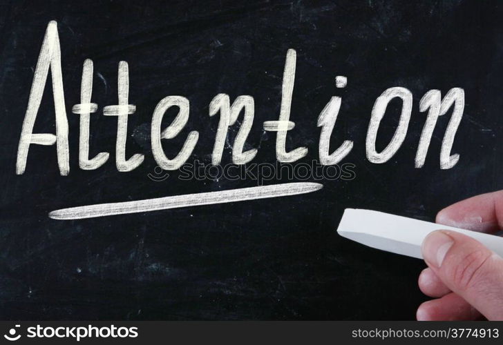 attention handwritten with chalk on a blackboard