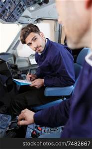 attentive aviation student listening to teahcer in cockpit